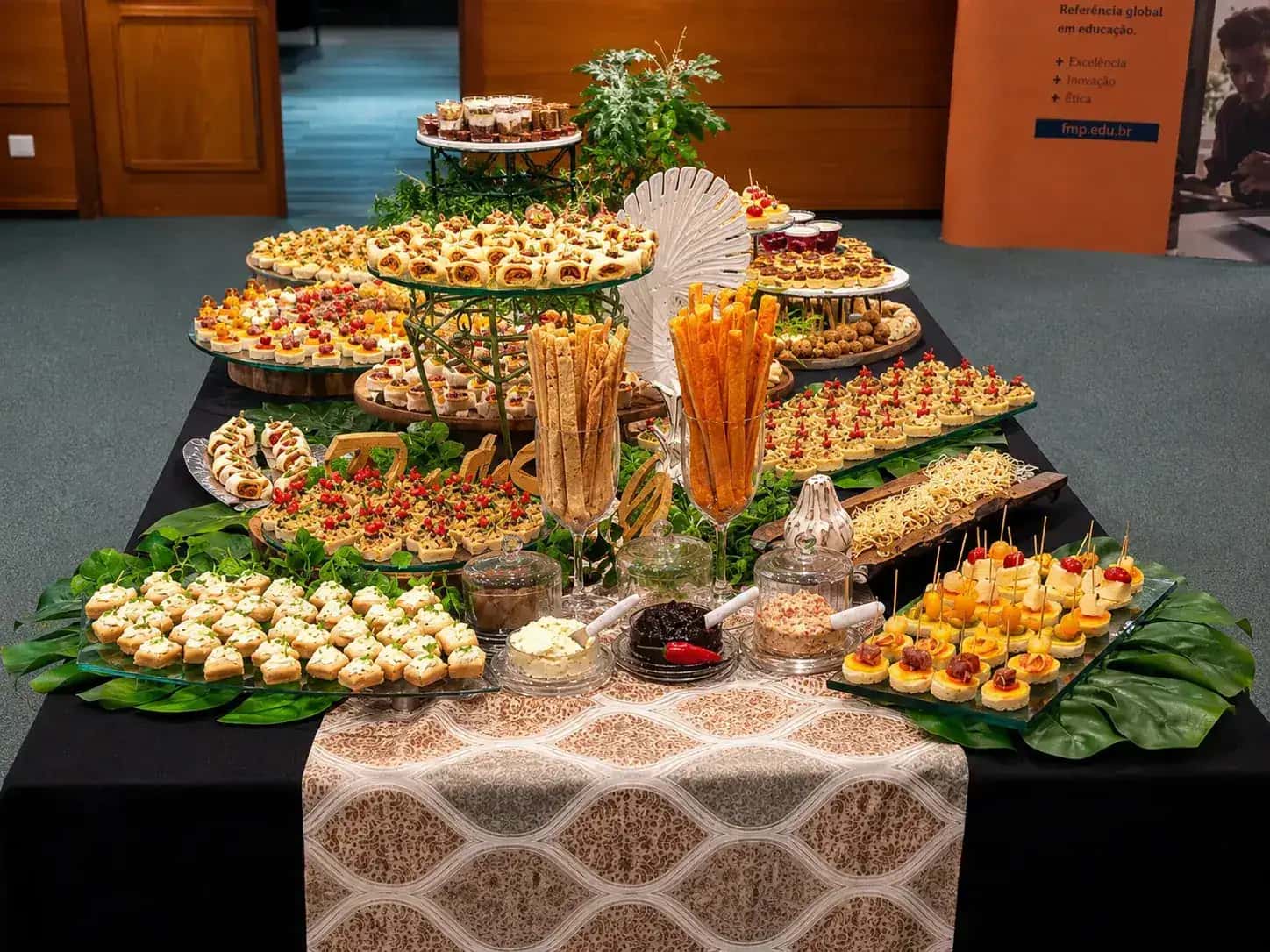 Mesa de catering corporativo da Porto Sabor com salgados, finger foods e doces para evento em Porto Alegre